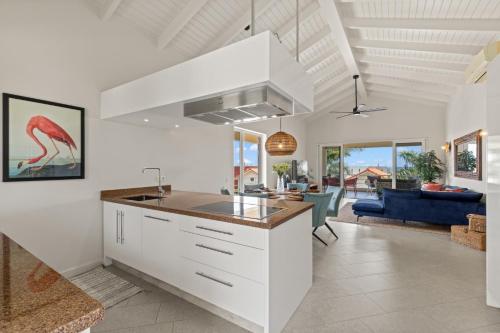 eine Küche mit weißen Schränken und ein Wohnzimmer in der Unterkunft Palm Piscadera · Ocean Views · Pool · Beaches in Dorp Sint Michiel