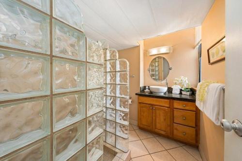 a bathroom with a wall of glass doors and a sink at Maui Kai 808 · MK 808 OceanFront 1BD Kaanapali Beach Ocean Views in Lahaina
