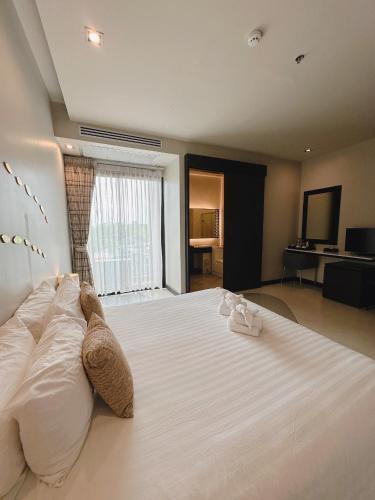 a bedroom with a large bed with two shoes on it at Sorin hotel in Surin