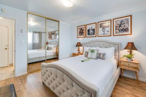 a bedroom with a large bed and a mirror at Menehune Shores 403 · MHS 403 Remodeled BeachFront 2BD Getaway in Kihei