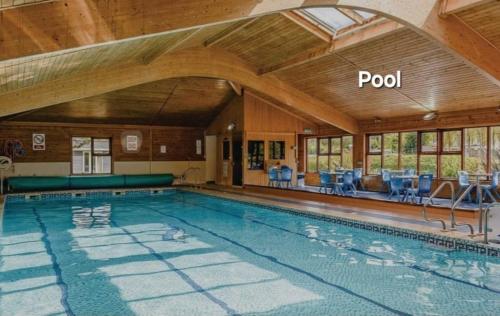 a large swimming pool in a house with a roof at Modern Newly Renovated Home on the Broads in Lowestoft