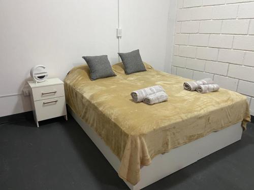 a bedroom with a bed with two towels on it at Sin Permiso Hospedaje in San Fernando del Valle de Catamarca