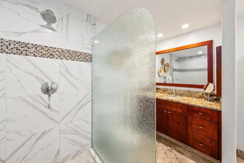 a bathroom with a shower with a glass door at Kaanapali Royal A303 · KRL A303 Relaxing Hawaiian 2BD on Golf Co in Lahaina