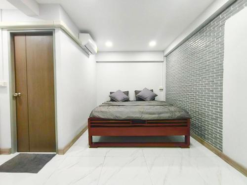 a bedroom with a bed and a brick wall at Number9 Bangkoknoi BKK Homestay in Bangkok