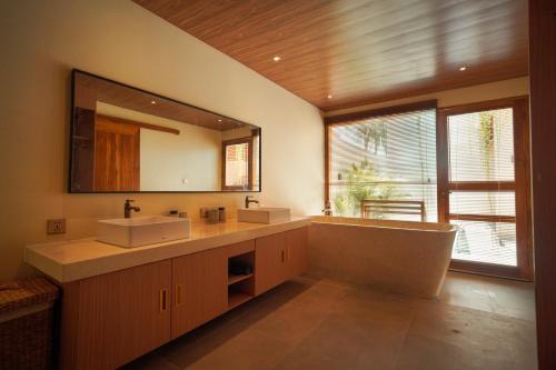a bathroom with two sinks and a large mirror at Enn Collection in Kuta Lombok