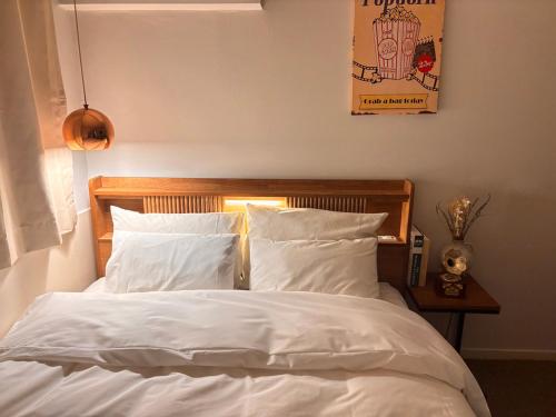 a bedroom with a bed with white sheets and pillows at Hotel Amy in Incheon
