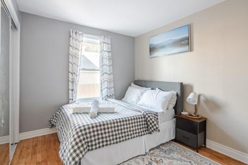 a bedroom with a bed and a window at Grande maison moderne 4 chambres - Spa Jaccuzi, Jardin & Parking gratuit - Idéale Familles et groupes in Saint-Jean-sur-Richelieu