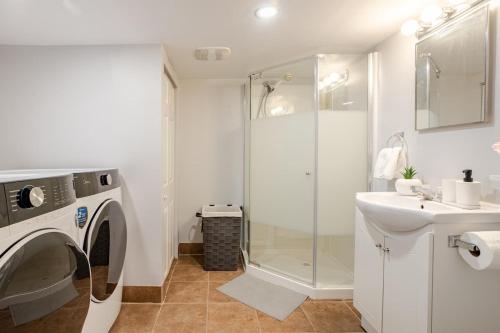 a bathroom with a washing machine and a sink at Grande maison moderne 4 chambres - Spa Jaccuzi, Jardin & Parking gratuit - Idéale Familles et groupes in Saint-Jean-sur-Richelieu