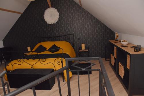 a bedroom with a yellow bed and a black wall at La Luxure- Loveroom in Maucomble