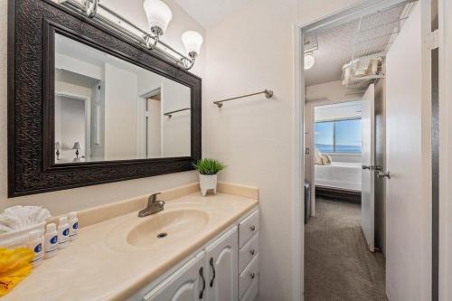 a bathroom with a sink and a mirror at Royal Kahana 909 · RK 909 OceanFront Condo w Beautiful Ocean Vie in Kahana