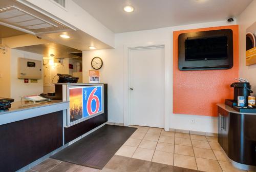 a waiting room with a tv and a counter at Motel 6-Lenexa, KS - Kansas City Southwest in Lenexa
