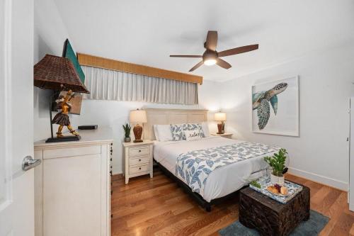 カハナにあるPapakea J106 · PK J106 Remodeled Condo w Ocean Views Pool ACのベッドと天井扇風機のある寝室