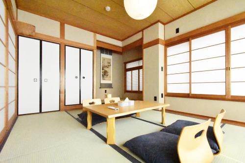 a room with a table and chairs and windows at 民泊富士てんのうじ MinpakuFujiTennoji in Osaka