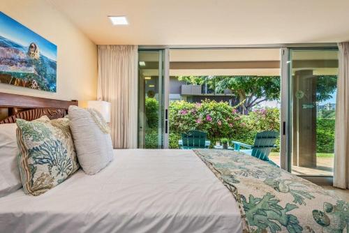 カアナパリにあるEldorado E102 · EL E102 Quiet Condo w Lanai AC Beach Cabana Gymのベッドルーム1室(大型ベッド1台、ガラスドア付)