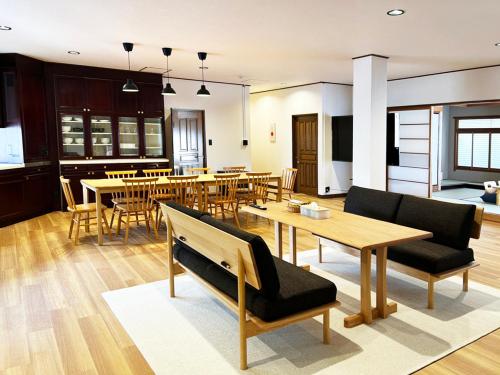 a living room with tables and chairs and a kitchen at 民泊富士てんのうじ MinpakuFujiTennoji in Osaka