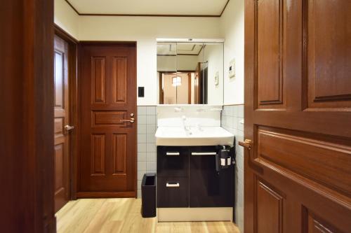 a bathroom with a sink and a mirror at 民泊富士てんのうじ MinpakuFujiTennoji in Osaka