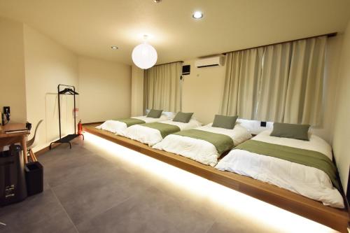 a bedroom with four beds with lights in it at 民泊富士てんのうじ MinpakuFujiTennoji in Osaka