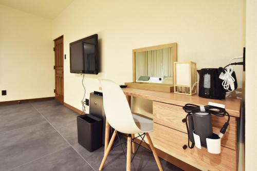 a room with a desk with a chair and a television at 民泊富士てんのうじ MinpakuFujiTennoji in Osaka