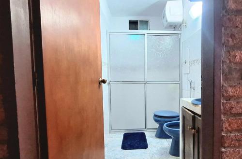 a bathroom with a blue toilet and a shower at Casa Hogar-Barbacoa y Garaje in Salto