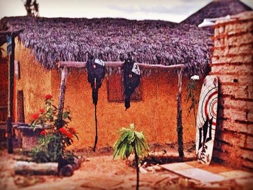 a house with clothes hanging on the side of it at Caju Bangalôs in Ponta do Anel