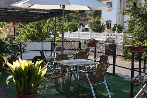 a table and chairs with an umbrella on a patio at Hotel Restaurante Atalaya in Comares