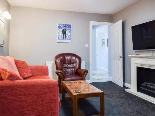 a living room with a couch and a chair at Pinecote in Bottesford