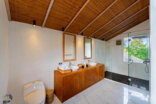 a bathroom with two sinks and a shower at Mahameru Uluwatu in Uluwatu