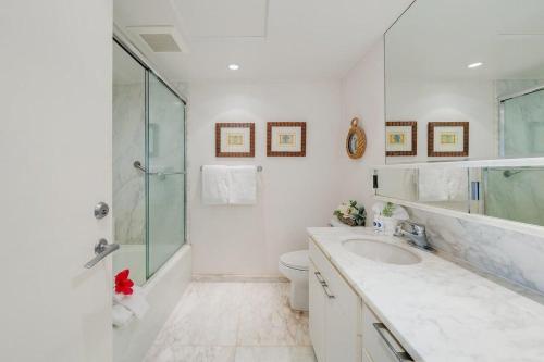 ラハイナにあるWhaler 712 · WHA 712 Kaanapali OceanFront Condo w Ocean Viewsのガラスのシャワーと洗面台を備えたバスルーム