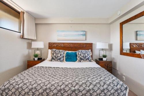 a bedroom with a bed and two lamps and a mirror at Kaanapali Shores 548 in Kahana