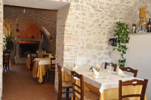 a dining room with two tables and a fireplace at Il Casale Di Ginetto in Cascia