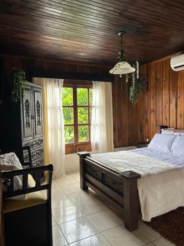 ÁngelesにあるCabaña acogedora a 20min de la Fortunaの大きなベッドと窓のある寝室