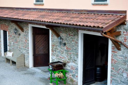 a brick building with a brown roof and a door at Le Macine Relais in Cairo Montenotte