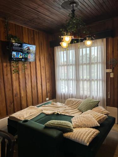 - un grand lit dans une chambre avec plafond dans l'établissement Cabaña acogedora a 20min de la Fortuna, à Ángeles