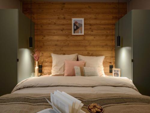 a bedroom with a large bed with a wooden wall at Chalet confortable 4 pers, vue montagne, terrasse - FR-1-840-55 in Aussois