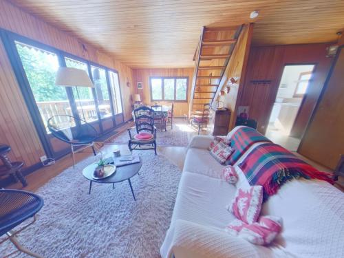 a living room with a white couch and a spiral staircase at Chalet au calme pour 10 pers, proche centre et activités - FR-1-834-9 in Les Rousses