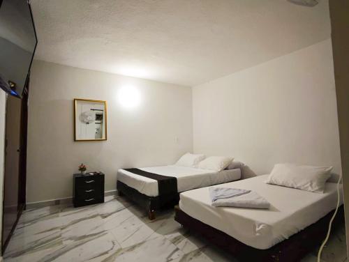 a hotel room with two beds and a mirror at Casa Eclat in Medellín