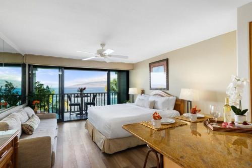 a bedroom with a bed and a living room at Lahaina Shores 507 · LS 507 West Maui Studio with Stunning Ocean in Lahaina