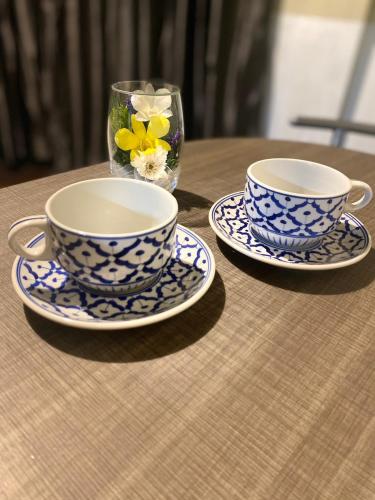 two blue and white cups and saucers on a table at Rhythm of life guesthouse 56 in Bangkok