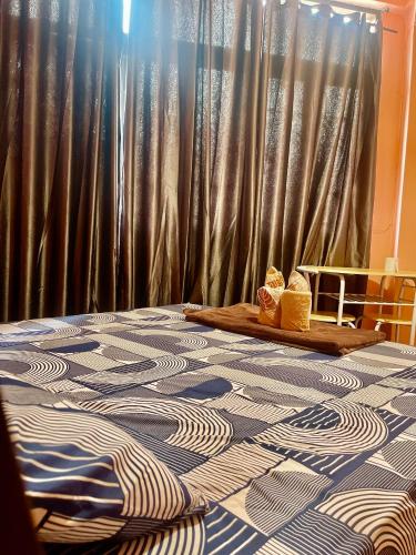 a room with a bed with a table with curtains at Rhythm of life guesthouse 56 in Bangkok