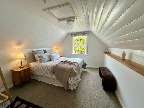 En eller flere senge i et værelse på La Vue - Boutique Waterfront Apartment, Akaroa