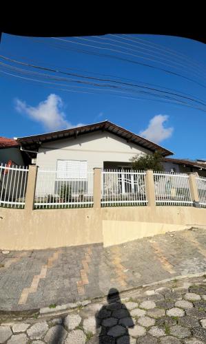 a house with a white fence in front of it at Casa para oktoberfest em Blumenau in Blumenau