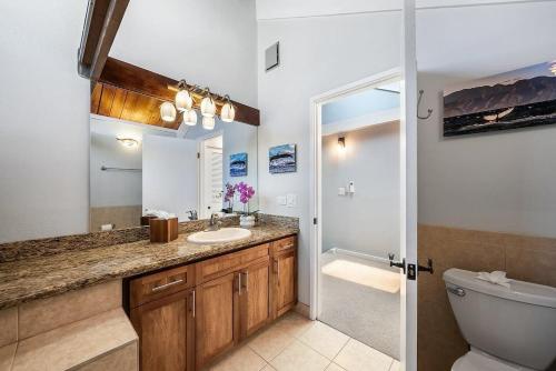 Un baño con lavabo, inodoro y espejo. en Kahana Village 32 · KHV 32 Direct Oceanfront Views Remodeled 2BD, en Kahana