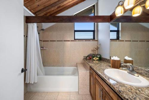 a bathroom with a white tub and a sink at Kahana Village 32 · KHV 32 Direct Oceanfront Views Remodeled 2BD in Kahana