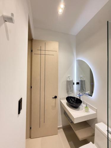 a bathroom with a sink and a mirror and a door at SYC Hotel Boutique in Arauca