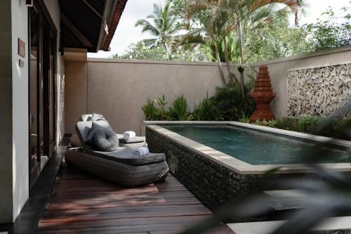 una piscina situata su un ponte accanto a una casa di Dedary Resort & Spa Ubud by Ini Vie Hospitality ad Ubud