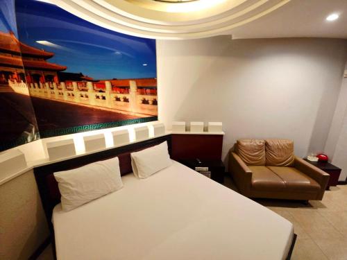a bedroom with a bed and a chair and a painting at Save Hotel เซฟ โฮเทล in Chon Buri