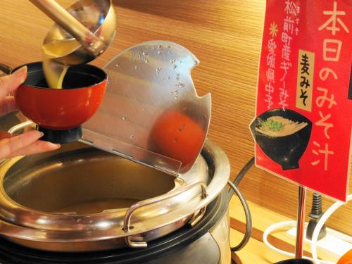 een persoon bereidt voedsel in een pot bij ジュラシック スパ &リゾート くつろぎの宿 樹楽 in Toon