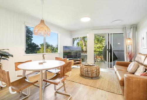 a living room with a table and a couch at Eco Beach Resort in Byron Bay