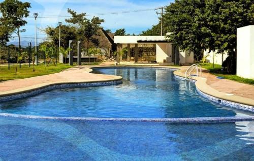 a large swimming pool with blue water at Comfortable apartment with pool and wifi in Puerto Vallarta