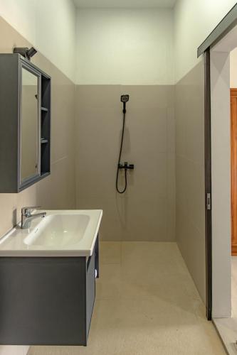 a bathroom with a sink and a shower at Satu Hati Hotel in Ekas